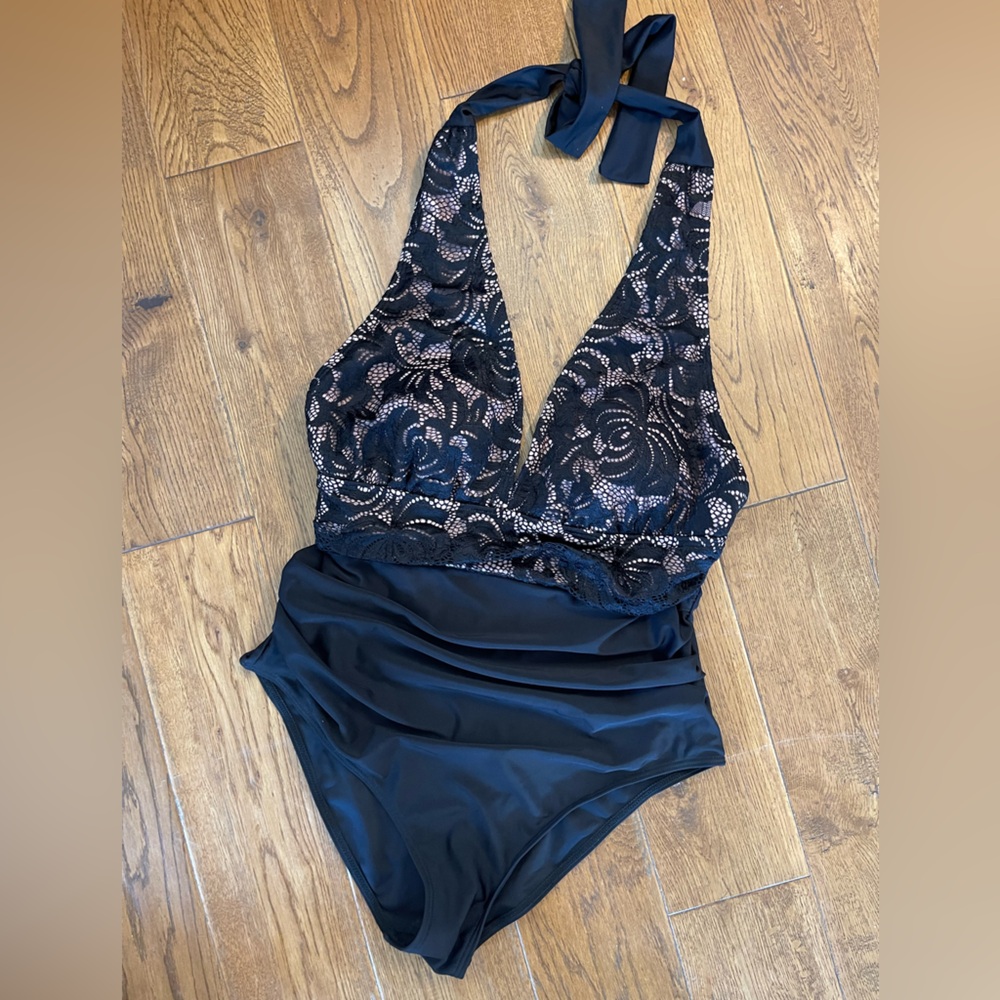 Black one piece swimsuit is definitely a black, not a navy color. Size M.